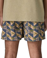 Back of man wearing Patagonia's men's  quick drying baggies shorts with repeating abstract tropical. Shorts have loose fitting and sit above the knees