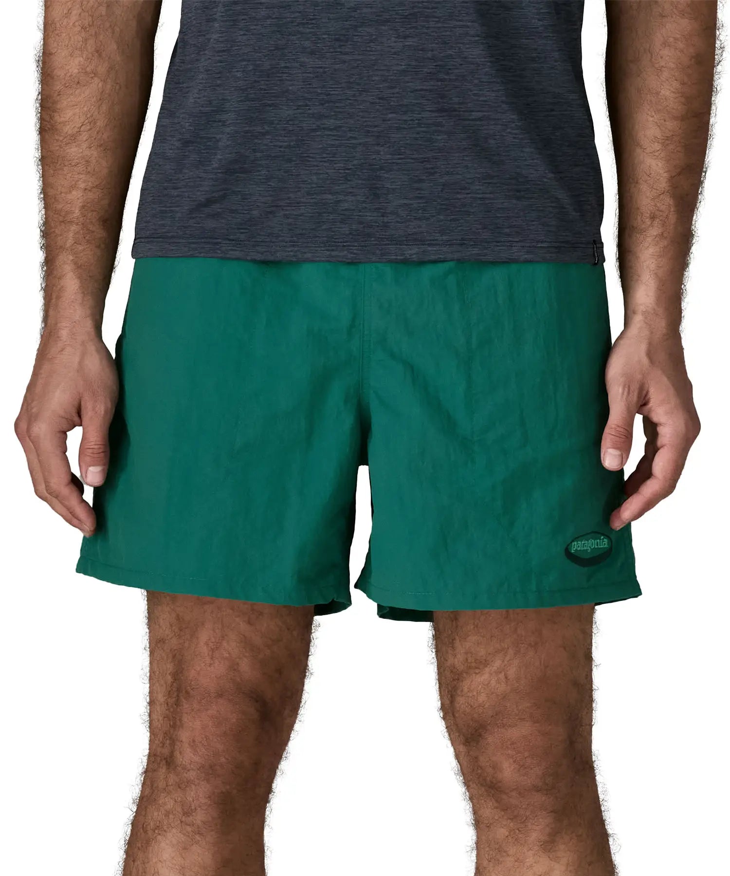 Man wearing Patagonia's men's  quick drying men's baggies shorts in teal green. Shorts have loose fitting and sit above the knees