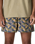 Man wearing Patagonia's men's  quick drying men's baggies shorts with repeating tropical design. Shorts have loose fitting and sit above the knees