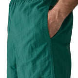 Man wearing Patagonias men's quick drying baggies shorts in teal green with hand in side pocket