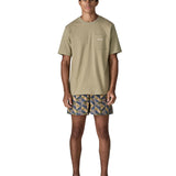 Man wearing Patagonia's quick drying baggies shorts with repeating abstract tropical design. Shorts have loose fitting 
