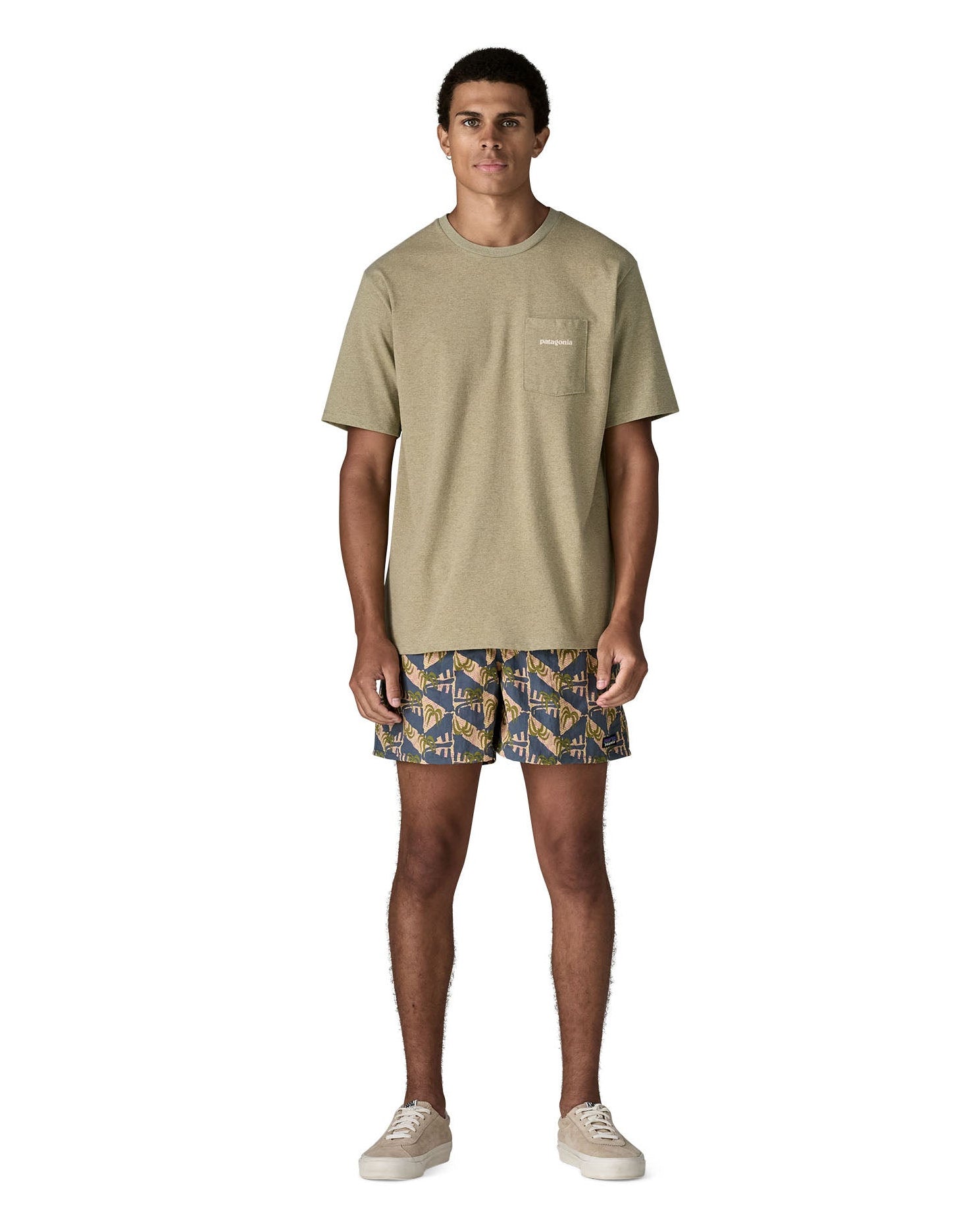 Man wearing Patagonia's quick drying baggies shorts with repeating abstract tropical design. Shorts have loose fitting 