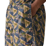 Man wearing Patagonia's men's quick drying baggies shorts with repeating abstract tropical design with hand in side pocket