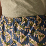 Close up of man wearing Patagonia's men's quick drying baggies shorts with repeating abstract tropical design. Shows elasticated waist band