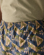 Close up of man wearing Patagonia's men's quick drying baggies shorts with repeating abstract tropical design. Shows elasticated waist band