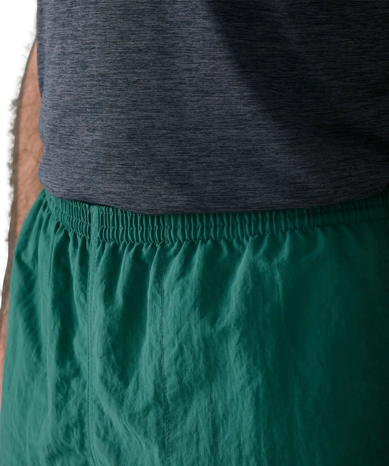 Close up of man wearing Patagonia's men's quick drying baggies shorts in teal green. Shows elasticated waist band
