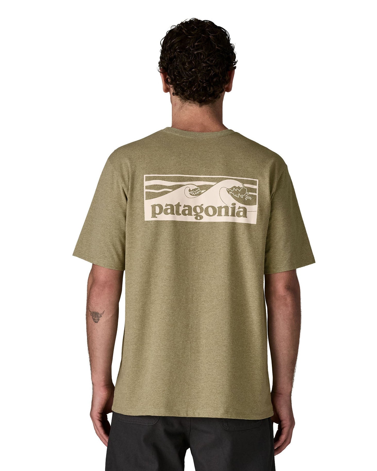 Man wearing Patagonia's men boardshort responsibili tee in light green. Shows a cream wave brand logo on the upper back