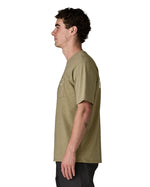 Side of man wearing Patagonia's men boardshort logo pocket responsibili tee in light green. T-shirt has a classic crewneck design