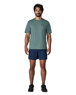 Man wearing Patagonia's men's capilene cool daily t-shirt in sage blue. T-shirt has a relaxed fit and sits at the hips
