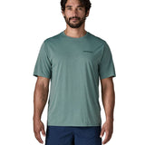 Man wearing Patagonia's men's capilene cool daily t-shirt in sage blue with small brand text on chest. 