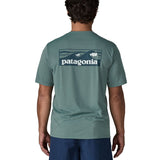 Man wearing Patagonia's men's capilene cool daily t-shirt in sage blue with wave brand graphic on upper back