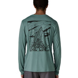 Man wearing Patagonia men's capilene cool daily long sleeve t-shirt in sage blue with black mountain graphic on upper back