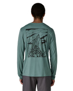 Man wearing Patagonia men's capilene cool daily long sleeve t-shirt in sage blue with black mountain graphic on upper back