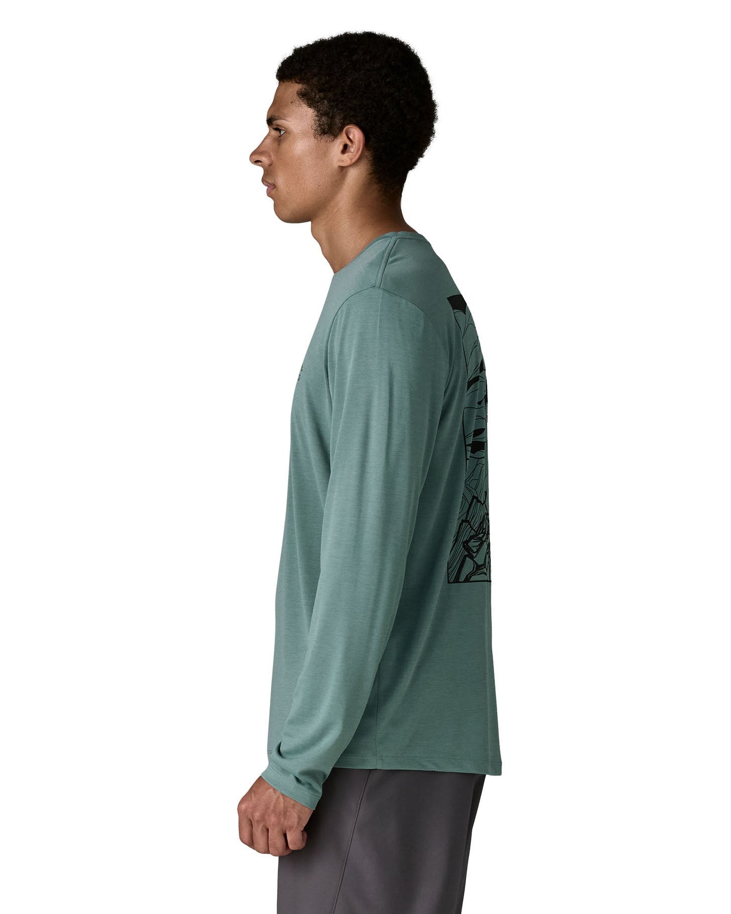 Side of man Patagonia men's capilene cool daily long sleeve t-shirt in sage blue. T-shirt has a relaxed and sits around the hips