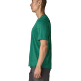 Side of man wearing Patagonia's men's capilene cool daily short sleeve t-shirt in green. T-shirt has a relaxed fit and sits at the hips