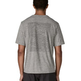 Man wearing Patagonia men's capilene cool daily short sleeve t-shirt in grey with large mountain brand logo on back