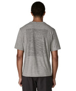 Man wearing Patagonia men's capilene cool daily short sleeve t-shirt in grey with large mountain brand logo on back
