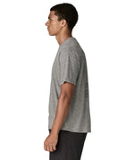 Side of man wearing Patagonia men's capilene cool daily short sleeve t-shirt in grey. T-shirt has a relaxed fit