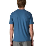 Back of man wearing Patagonia men's capilene trail short sleeve t-shirt in blue.  T-shirt has a relaxed fit and sits at the hips