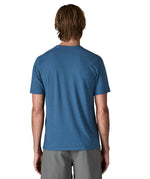Back of man wearing Patagonia men's capilene trail short sleeve t-shirt in blue.  T-shirt has a relaxed fit and sits at the hips