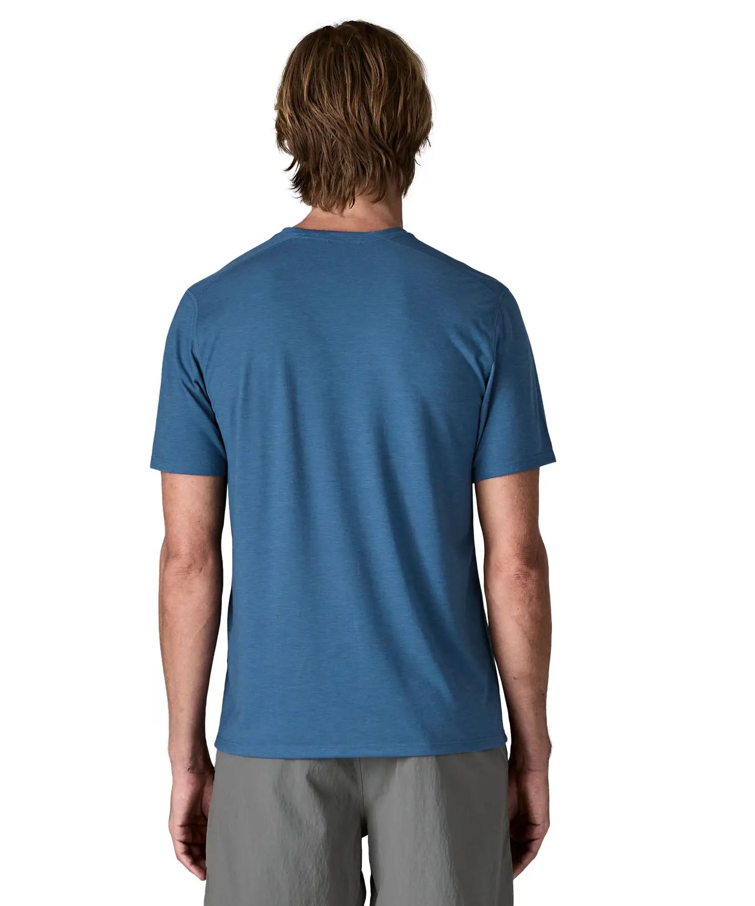 Back of man wearing Patagonia men's capilene trail short sleeve t-shirt in blue.  T-shirt has a relaxed fit and sits at the hips
