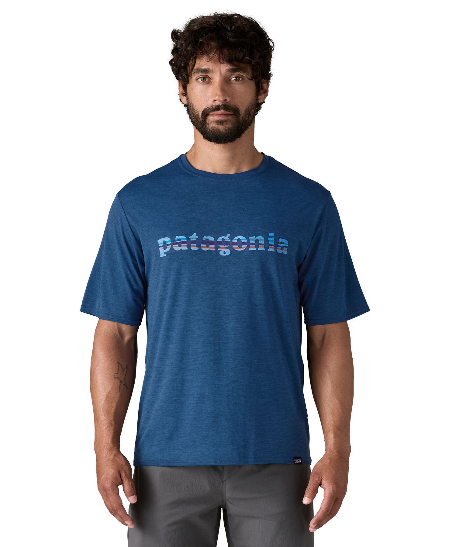 A man wearing the Patagonia blue capilene cool daily short sleeve tshirt in clement with branding on the front available at Babipur