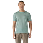 A man wearing The Patagonia Men's Capilene Cool Merino Graphic T-Shirt in thermal blue