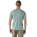The back of a man wearing The Patagonia Men's Capilene Cool Merino Graphic T-Shirt in thermal blue