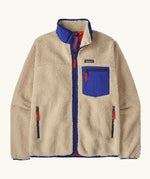 Patagonia Men’s Classic Retro-X Fleece Jacket in beige with cobalt blue trim. Features a full front zip, chest and side pockets