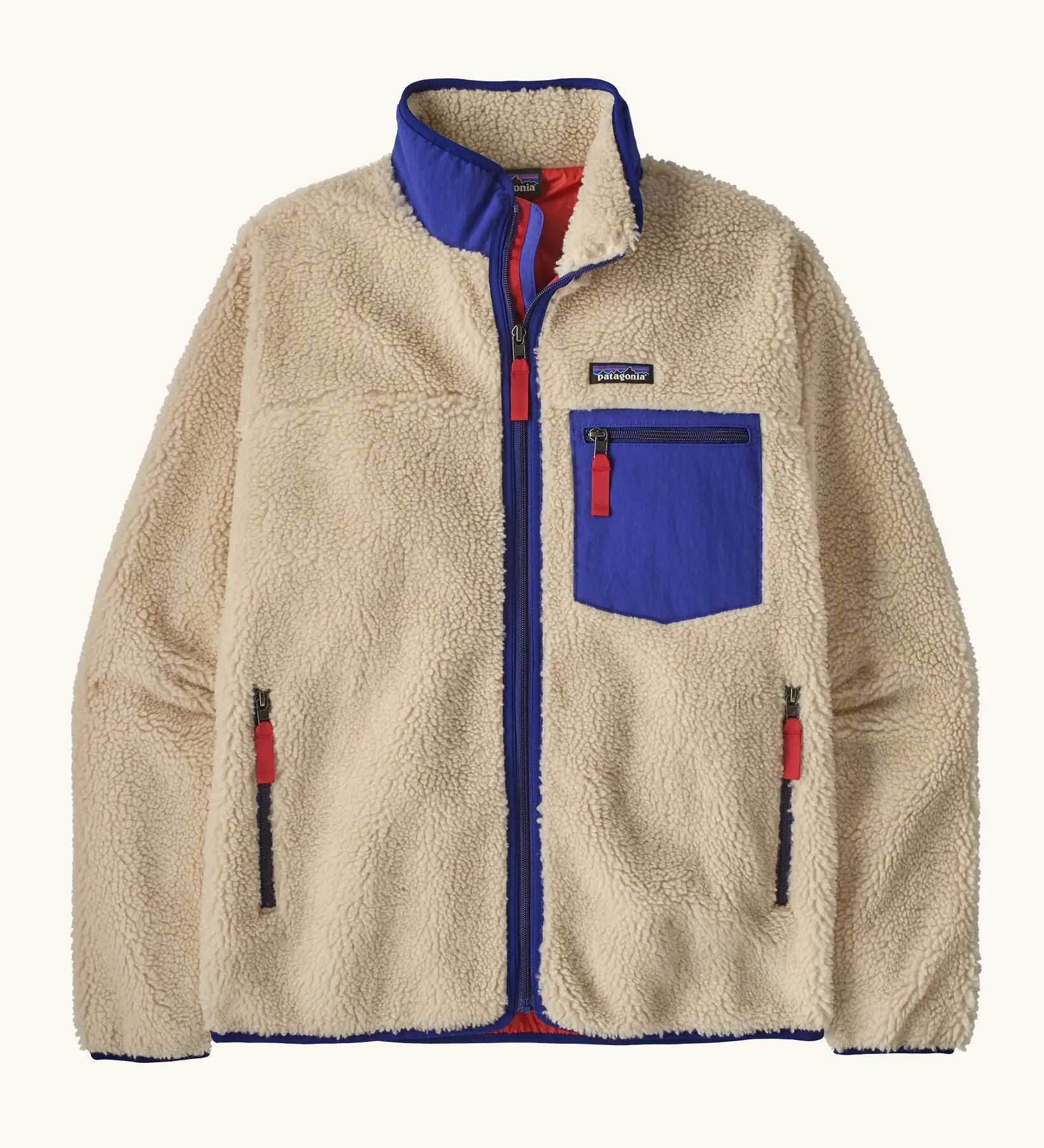 Patagonia Men’s Classic Retro-X Fleece Jacket in beige with cobalt blue trim. Features a full front zip, chest and side pockets