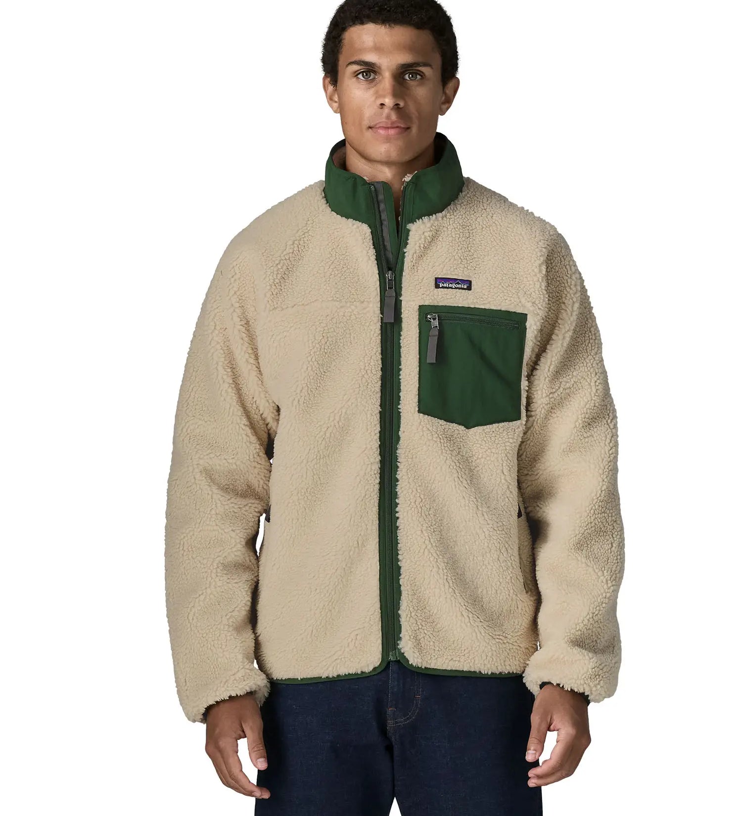 Man wearing the Patagonia classic retro x jacket in natural with green trim. Showing front zip, chest pocket and turned up collar 