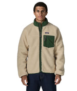 Man wearing the Patagonia classic retro x jacket in natural with green trim. Showing front zip, chest pocket and turned up collar 