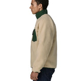 Side of man wearing the Patagonia classic retro x jacket in natural showing the green turned up collar and chest pocket. Fleece has a regular fit