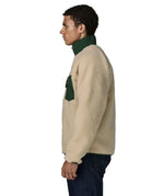 Side of man wearing the Patagonia classic retro x jacket in natural showing the green turned up collar and chest pocket. Fleece has a regular fit