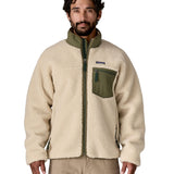 A man wearing the Patagonia classic retro x jacket in natural/green available at Babipur. A thick fleece jacket in beige colour with a green trim, features a full length zip.turn up collar anda chest pocket.