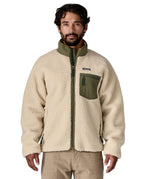 A man wearing the Patagonia classic retro x jacket in natural/green available at Babipur. A thick fleece jacket in beige colour with a green trim, features a full length zip.turn up collar anda chest pocket.