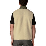 Back of man wearing Patagonia's classic retro x warm fleece vest in beige with green trim. Gilet has a regular fit