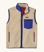 Patagonia men's classic retro x warm fleece vest in beige with cobalt blue trim. Features a front zip, chest and side pockets