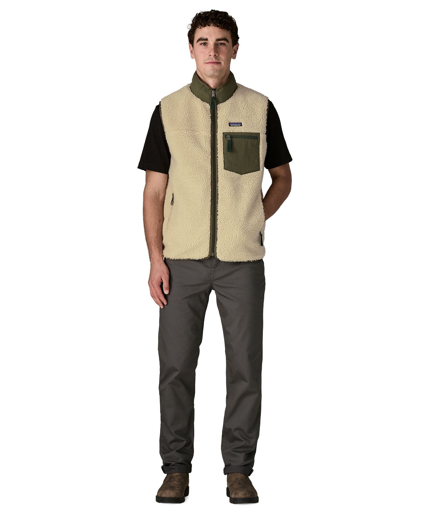 Man wearing Patagonia's classic retro x warm fleece vest in beige with green trim with full front zip fastened. Gilet has a regular fit