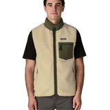 Man wearing Patagonia's classic retro x warm fleece vest in beige with green trim showing full front zip, turned up collar, chest and side pockets