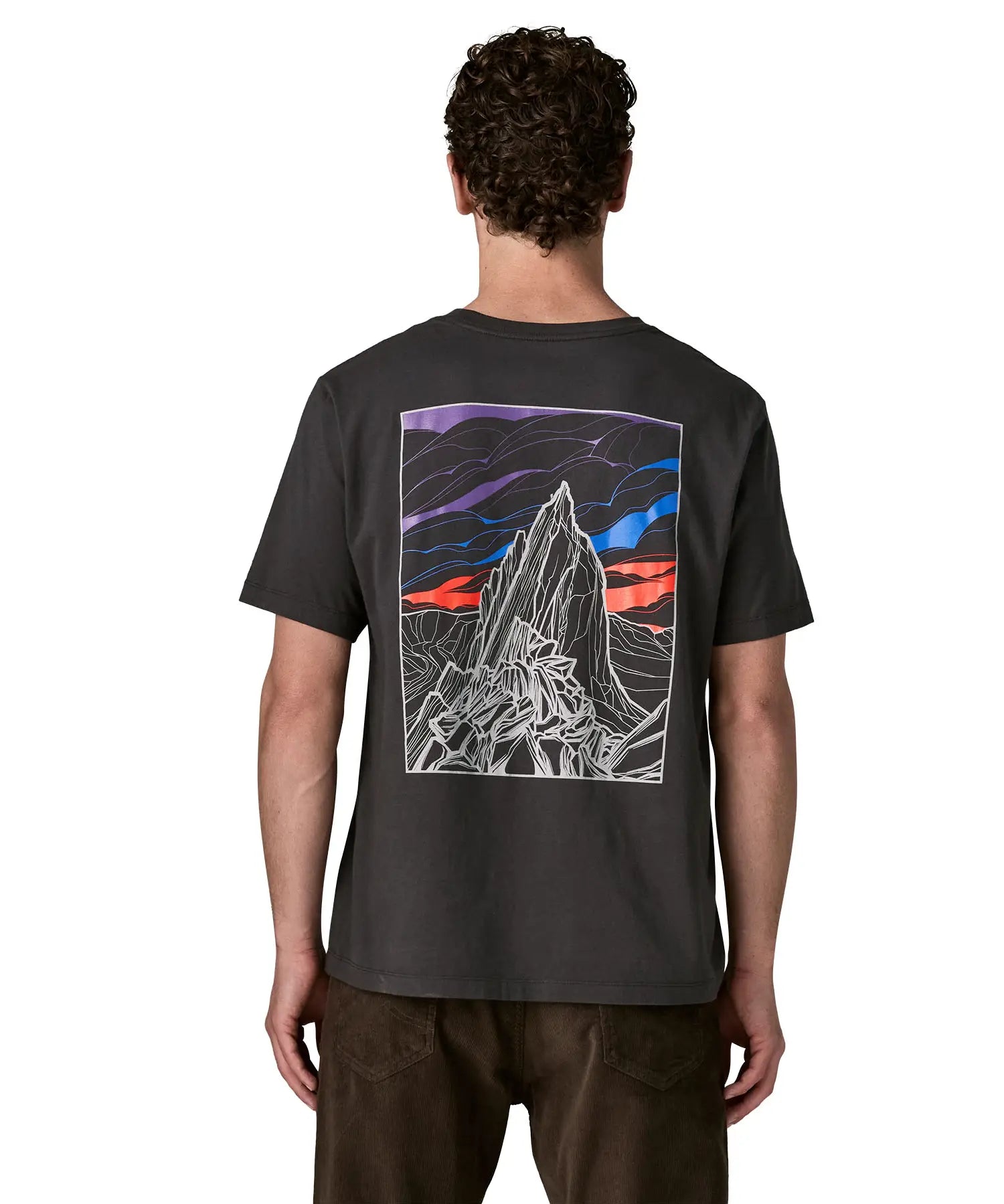 Man wearing Patagonia's  cloud crag short sleeve t-shirt in black showing a large mountain ridge graphic on the back