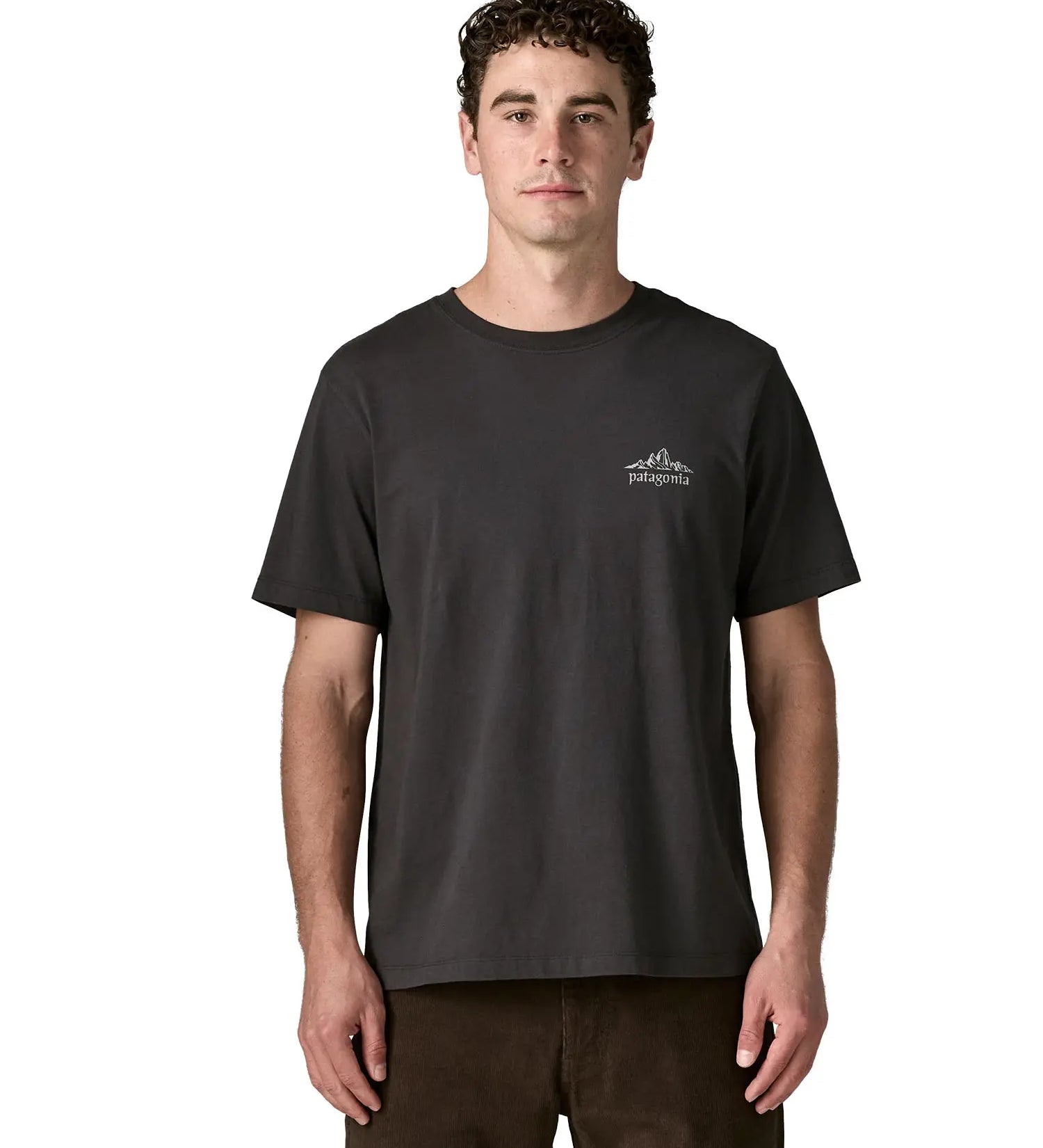 Man wearing Patagonia's  cloud crag short sleeve t-shirt in black showing a small mountain ridge graphic on the chest