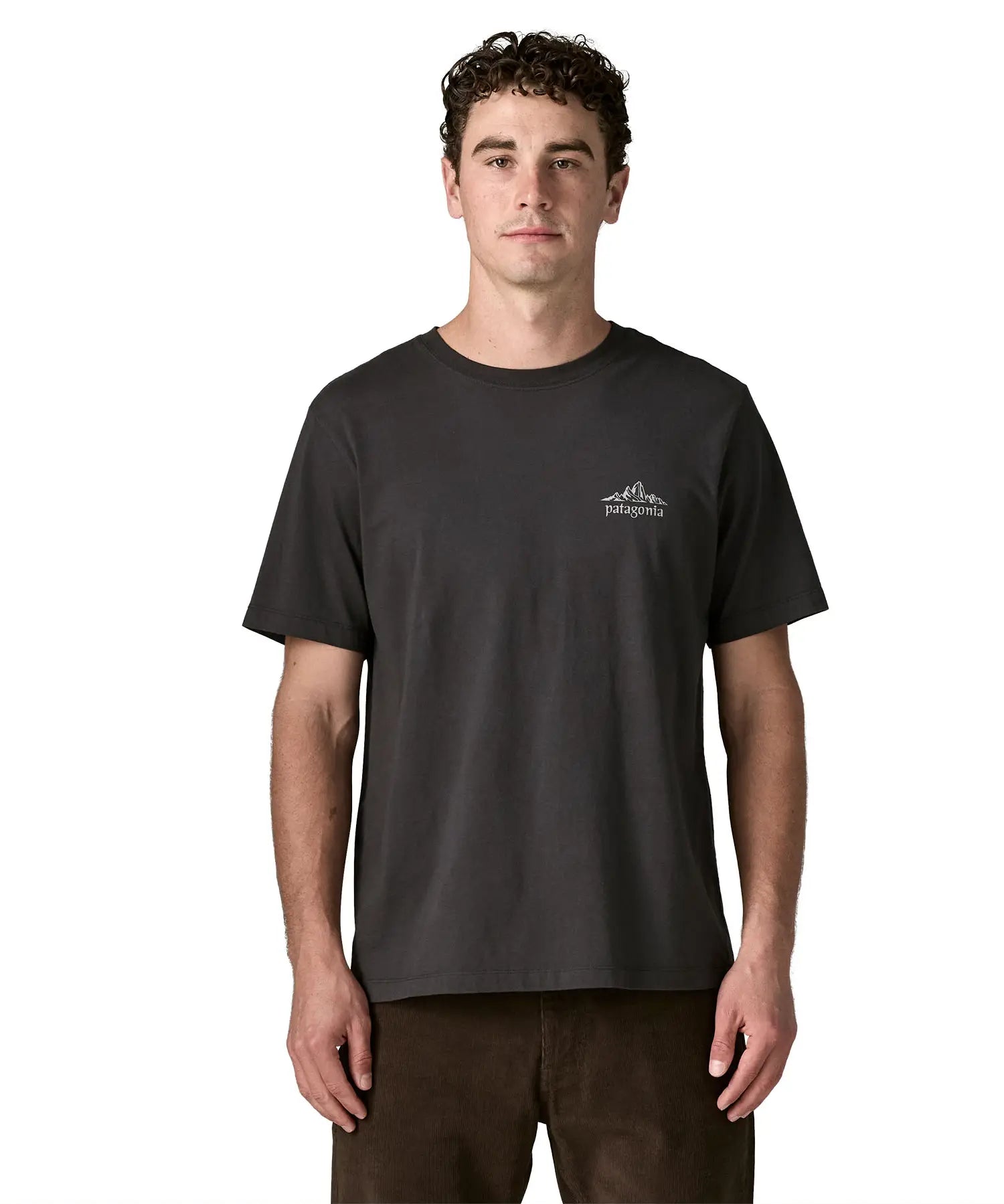 Man wearing Patagonia's  cloud crag short sleeve t-shirt in black showing a small mountain ridge graphic on the chest