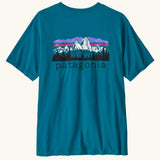 Patagonia men's fitz roy foothills short sleeve t-shirt in glacier blue showing a large mountain branded print on the upper back. 