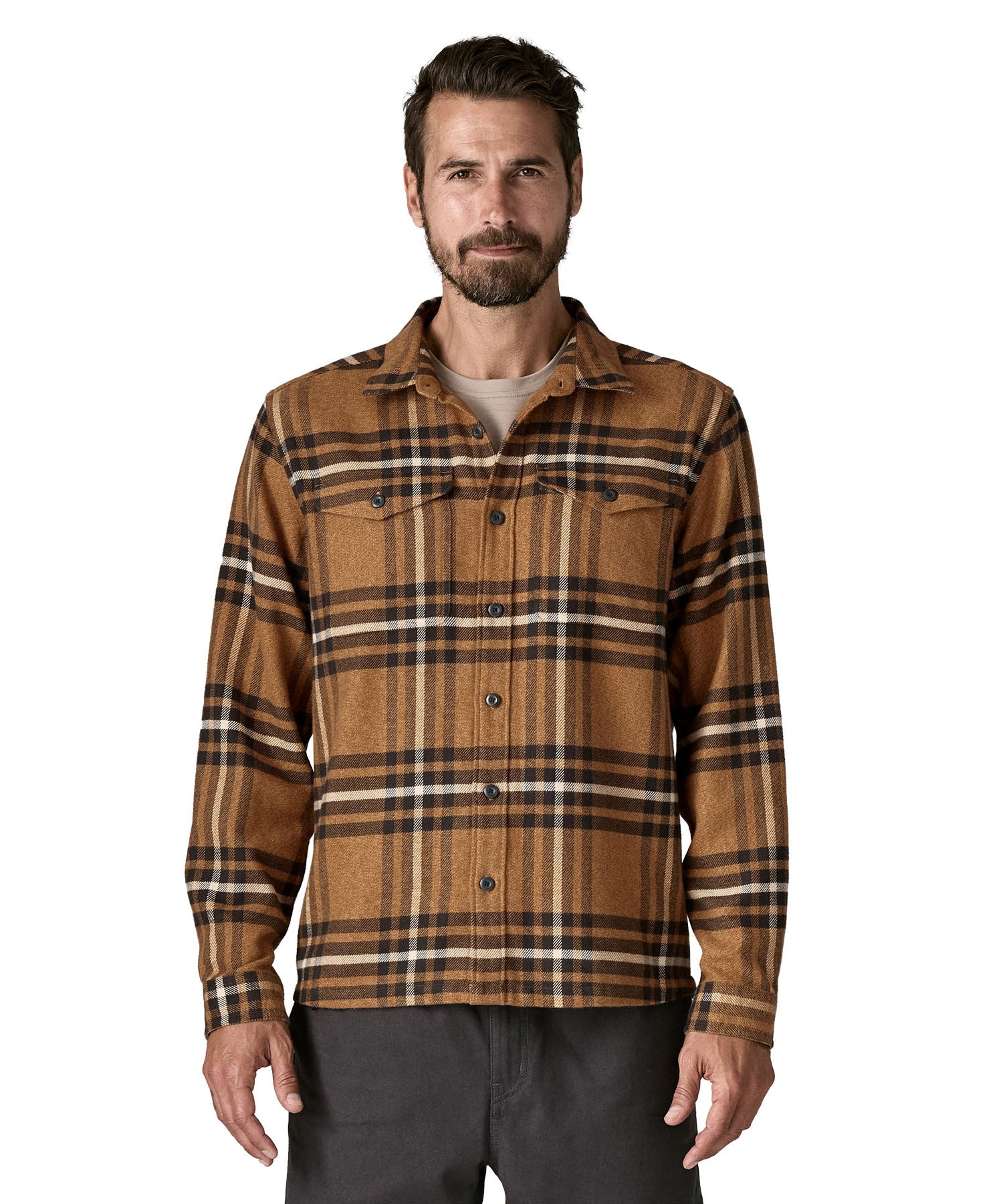  A man wearing the Patagonia fjord flannel shirt in catch deer brown available at Babipur. A thick fleece in a brown chequered design. Features button fasteners and 2 chest pockets 