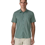 Man wearing Patagonia men's buttoned short sleeve shirt in sage blue. Shirt has a relaxed fit and sits at the hips