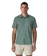 Man wearing Patagonia men's buttoned short sleeve shirt in sage blue. Shirt has a relaxed fit and sits at the hips