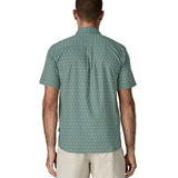 Back of man wearing Patagonia men's buttoned short sleeve shirt in sage blue. Shirt has relaxed fit and sits at the hips