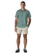 Man wearing Patagonia men's buttoned short sleeve shirt in sage blue with repeating mini sun pattern design. 