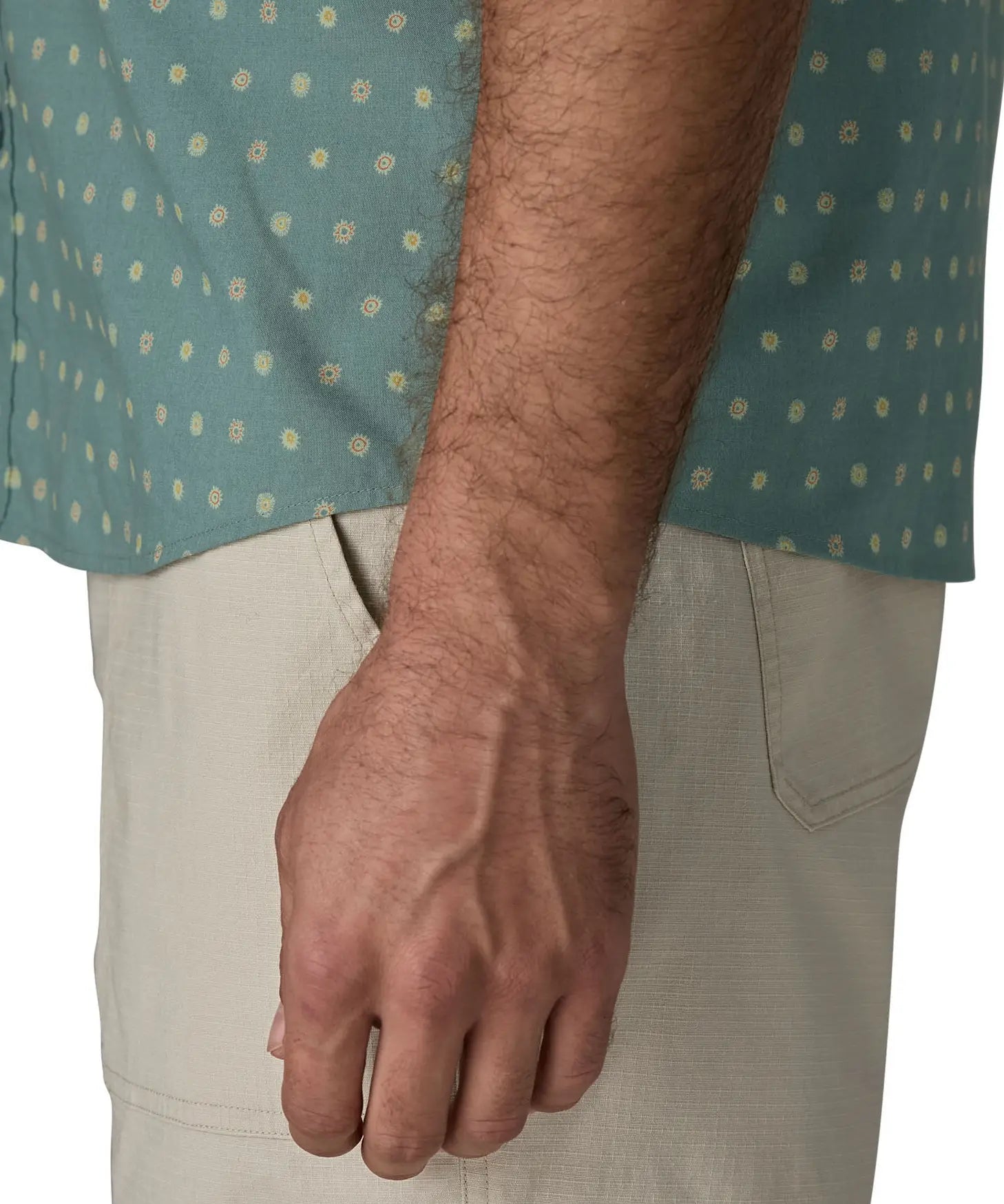 Hem of Patagonia men's buttoned short sleeve shirt in sage blue with repeating mini sun pattern design 
